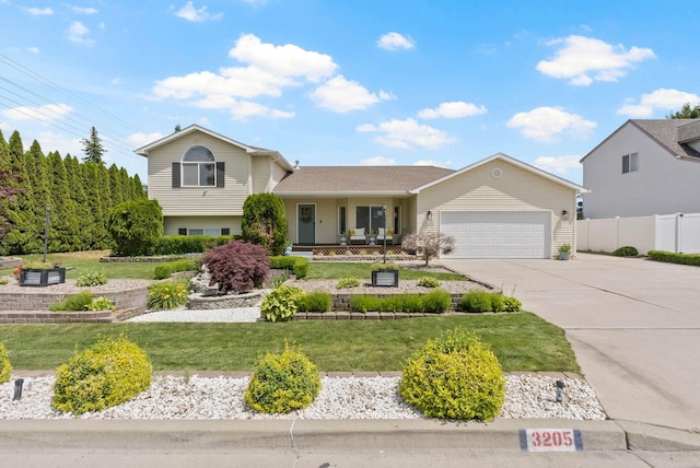 3205 S Mcdonald St, Spokane Valley, WA 99206 - tri-level home featuring a garage, driveway, and covered porch