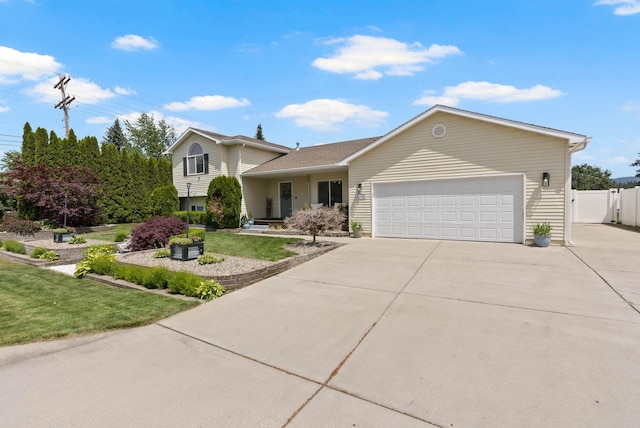 3205 S Mcdonald St, Spokane Valley, WA 99206 - tri-level home featuring a garage, driveway, and a gate