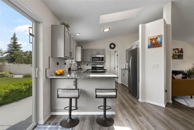 3205 S Mcdonald St, Spokane Valley, WA 99206 - kitchen featuring gray cabinetry, appliances with stainless steel finishes, a peninsula, a skylight, and dark wood-style flooring