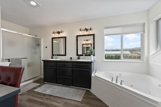 3205 S Mcdonald St, Spokane Valley, WA 99206 - bathroom with double vanity, a stall shower, a whirlpool tub, and wood finished floors