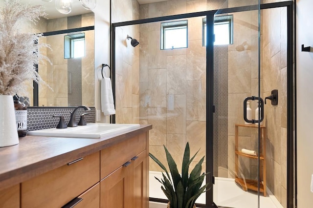 24493 E Pinnacle Ct # D, Liberty Lake, WA 99019 - full bathroom featuring vanity, plenty of natural light, a stall shower, backsplash, and tile walls