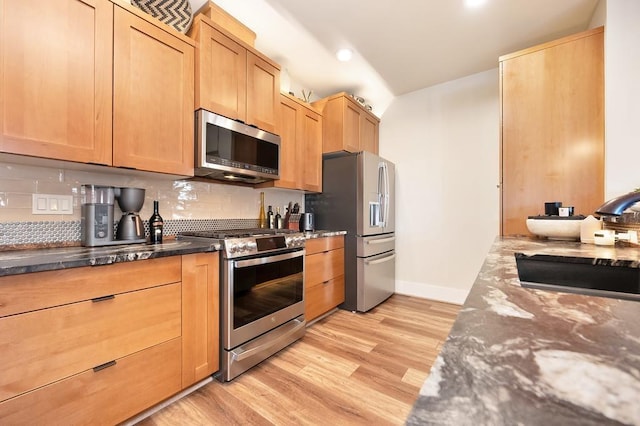 24493 E Pinnacle Ct # D, Liberty Lake, WA 99019 - kitchen featuring appliances with stainless steel finishes, tasteful backsplash, light wood-style flooring, dark stone countertops, and recessed lighting
