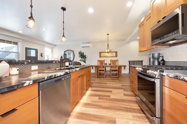 24493 E Pinnacle Ct # D, Liberty Lake, WA 99019 - kitchen featuring appliances with stainless steel finishes, an AC wall unit, tasteful backsplash, light wood-type flooring, and recessed lighting