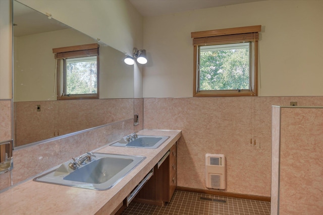 3303 W 8th Ave, Spokane, WA 99224 - bathroom featuring healthy amount of natural light, tile walls, wainscoting, double vanity, and tile patterned flooring