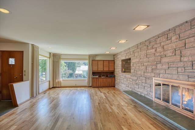 3303 W 8th Ave, Spokane, WA 99224 - unfurnished living room with a stone fireplace and light wood-style floors