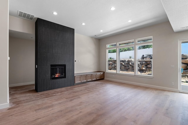 13306 N Starling Ln, Spokane, WA 99208 - unfurnished living room with light wood-style flooring, recessed lighting, and a fireplace