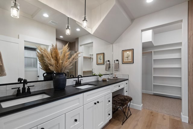 13306 N Starling Ln, Spokane, WA 99208 - bathroom with double vanity, wood finished floors, a spacious closet, and recessed lighting
