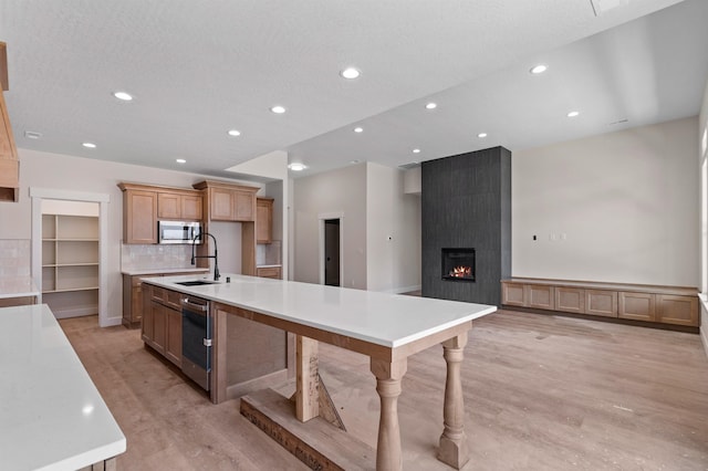 13306 N Starling Ln, Spokane, WA 99208 - kitchen featuring appliances with stainless steel finishes, a spacious island, recessed lighting, light countertops, and a large fireplace