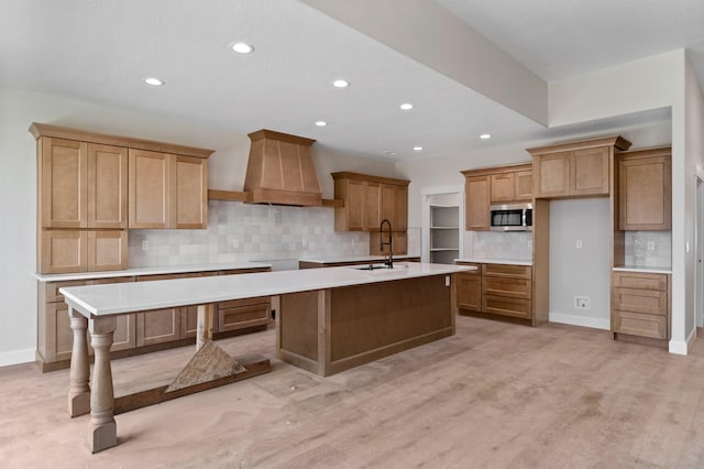 13306 N Starling Ln, Spokane, WA 99208 - kitchen featuring stainless steel microwave, custom range hood, a center island with sink, decorative backsplash, and recessed lighting