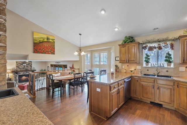 6709 S Moran View St, Spokane, WA 99224 - kitchen with a fireplace, stainless steel dishwasher, dark wood-style flooring, light countertops, and brown cabinetry