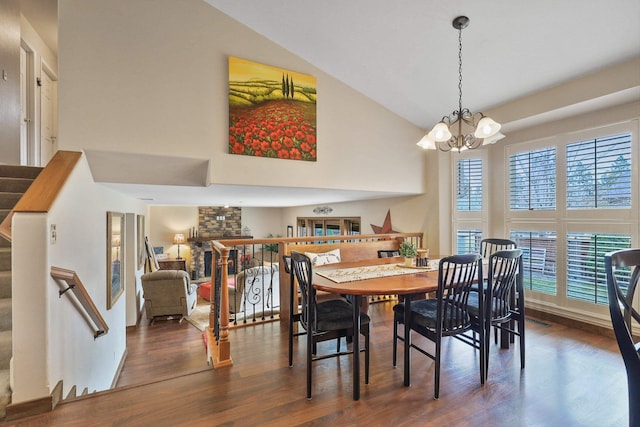 6709 S Moran View St, Spokane, WA 99224 - dining room featuring a chandelier, wood finished floors, high vaulted ceiling, stairs, and a stone fireplace