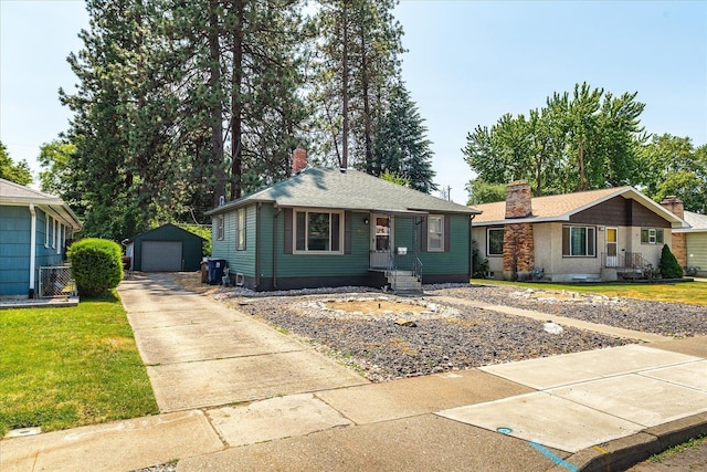 3829 W Broad Ave, Spokane, WA 99205 - view of front of house with a chimney, driveway, a garage, an outbuilding, and a front lawn