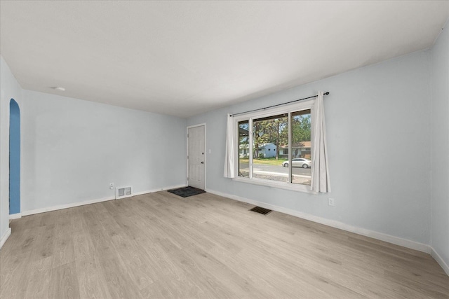 3829 W Broad Ave, Spokane, WA 99205 - unfurnished living room with light wood-style flooring and arched walkways