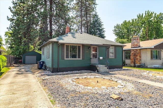 3829 W Broad Ave, Spokane, WA 99205 - view of front of home with a chimney, concrete driveway, a detached garage, an outbuilding, and roof with shingles