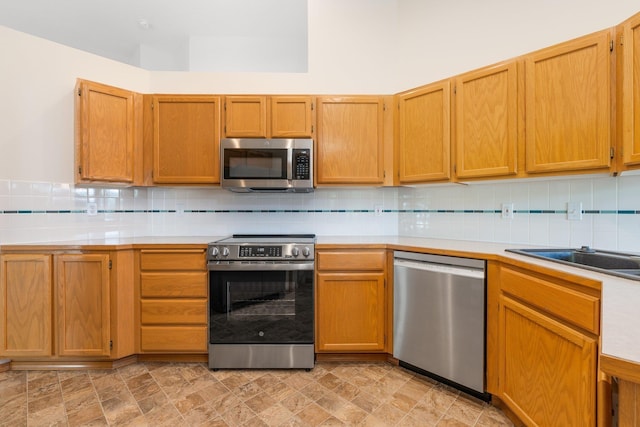 2106 E Turnberry Ln, Spokane, WA 99223 - kitchen featuring appliances with stainless steel finishes, light countertops, and decorative backsplash