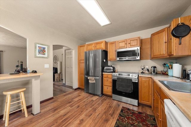 1481 Northshore Diamond Lake Rd, Newport, WA 99156 - kitchen with stainless steel appliances, wood finished floors, arched walkways, and light countertops