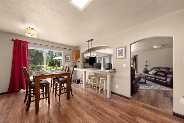 1481 Northshore Diamond Lake Rd, Newport, WA 99156 - dining room with arched walkways, wood finished floors, and a textured ceiling