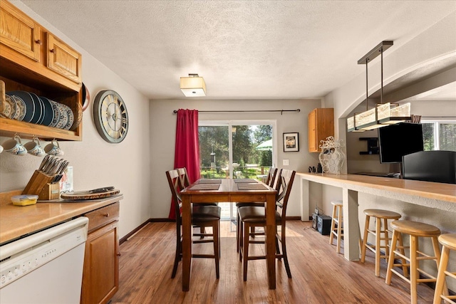1481 Northshore Diamond Lake Rd, Newport, WA 99156 - dining room with healthy amount of natural light, light wood-style flooring, and a textured ceiling