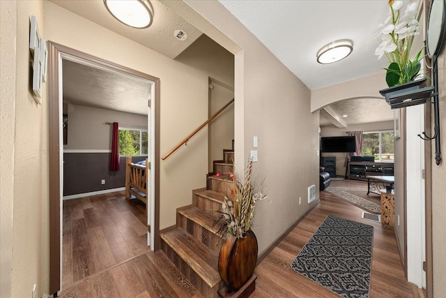 1481 Northshore Diamond Lake Rd, Newport, WA 99156 - foyer with arched walkways, wood finished floors, healthy amount of natural light, stairs, and a textured ceiling