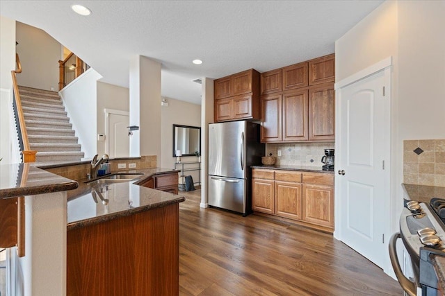 4213 S Cook St, Spokane, WA 99223 - kitchen featuring freestanding refrigerator, range, dark stone counters, decorative backsplash, and dark wood finished floors
