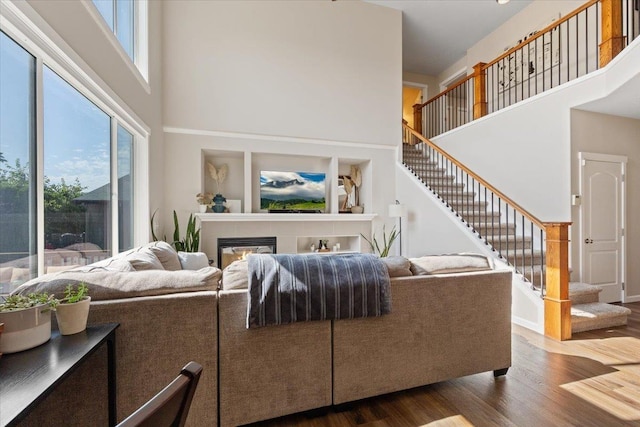 4213 S Cook St, Spokane, WA 99223 - living room with a towering ceiling, dark wood-style flooring, stairs, and a glass covered fireplace
