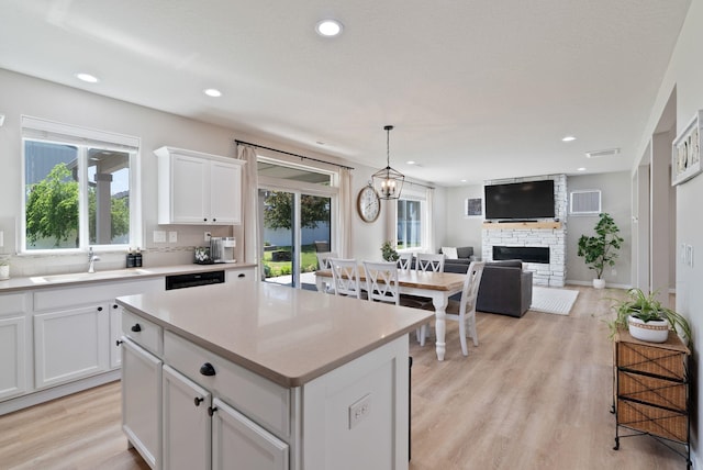1248 W Staples Rd, Post Falls, ID 83854 - kitchen with a fireplace, plenty of natural light, white cabinetry, a kitchen island, and recessed lighting