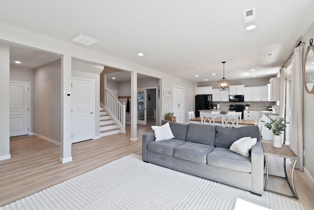 1248 W Staples Rd, Post Falls, ID 83854 - living room featuring stairway, light wood finished floors, and recessed lighting