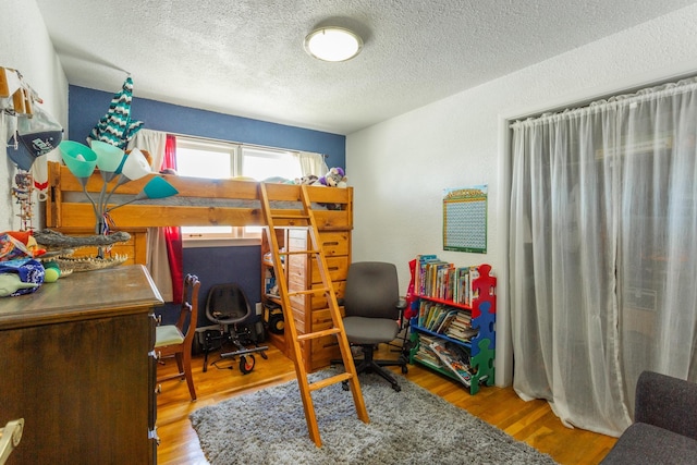 5711 N Ash St, Spokane, WA 99205 - bedroom featuring a textured ceiling, wood finished floors, and a desk
