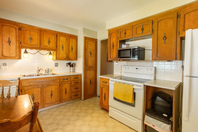 5711 N Ash St, Spokane, WA 99205 - kitchen with white appliances, brown cabinets, backsplash, light countertops, and a textured ceiling
