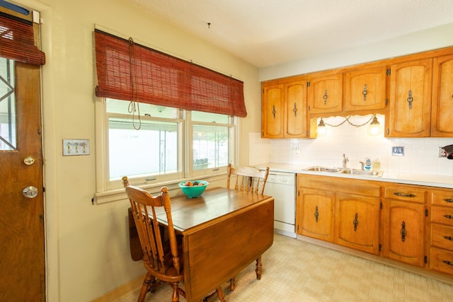 5711 N Ash St, Spokane, WA 99205 - kitchen featuring white dishwasher, light countertops, tasteful backsplash, and brown cabinetry