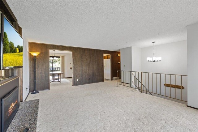 3810 S Moffitt Rd, Spokane Valley, WA 99206 - spare room with a chandelier, a textured ceiling, light carpet, and wooden walls