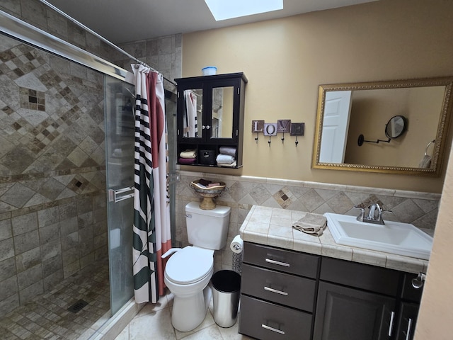 6321 310th St NW Stanwood, Unit Stanwood, WA 98292 - bathroom featuring a skylight, a shower stall, tile walls, vanity, and tile patterned flooring