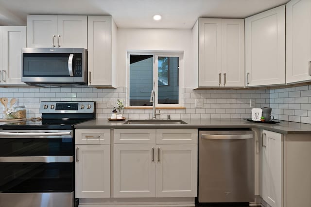 2121 W Cleveland Ave, Spokane, WA 99205 - kitchen with stainless steel appliances, dark countertops, white cabinets, tasteful backsplash, and recessed lighting