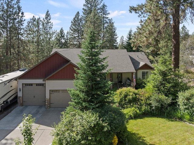 4812 S Wildwood Ln, Spokane, WA 99206 - view of front of house featuring concrete driveway, an attached garage, a front yard, and stone siding