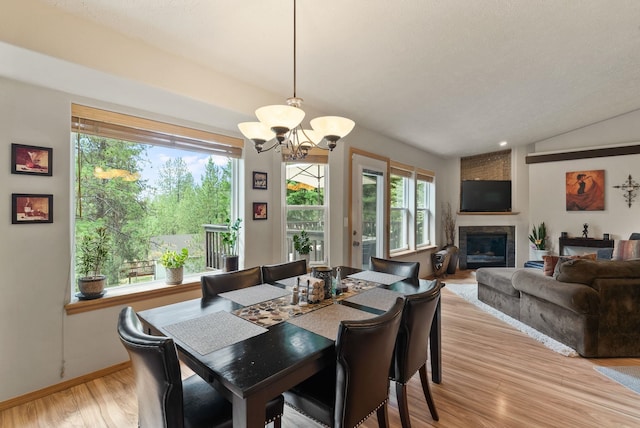 4812 S Wildwood Ln, Spokane, WA 99206 - dining area with a chandelier, a glass covered fireplace, and light wood-style flooring