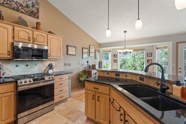 4812 S Wildwood Ln, Spokane, WA 99206 - kitchen with stainless steel appliances, vaulted ceiling, hanging light fixtures, tasteful backsplash, and a textured ceiling