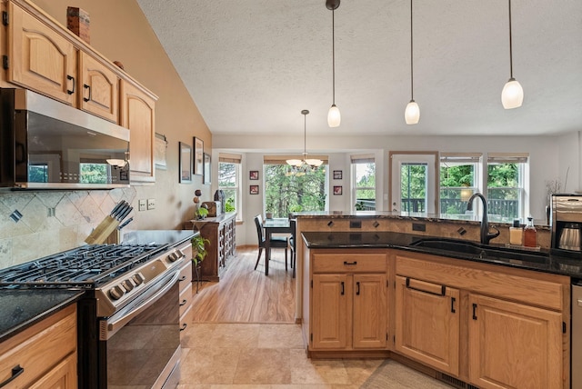 4812 S Wildwood Ln, Spokane, WA 99206 - kitchen featuring appliances with stainless steel finishes, healthy amount of natural light, backsplash, dark stone counters, and a textured ceiling