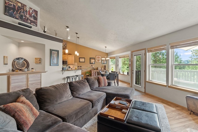 4812 S Wildwood Ln, Spokane, WA 99206 - living room with a textured ceiling, vaulted ceiling, light wood-style floors, and a chandelier