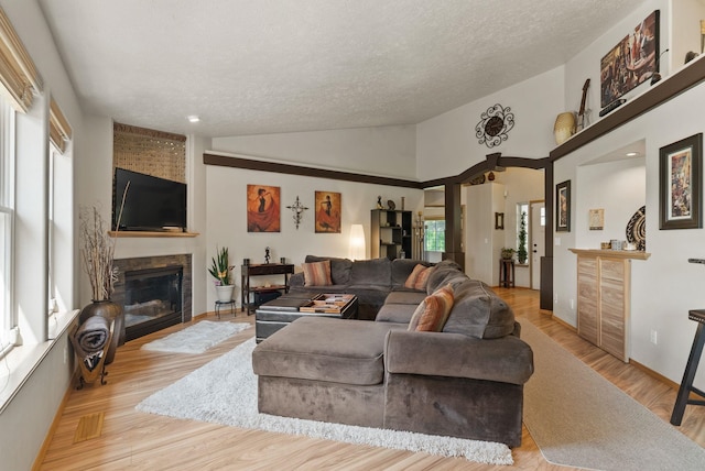 4812 S Wildwood Ln, Spokane, WA 99206 - living area with a large fireplace, a textured ceiling, lofted ceiling, and wood finished floors