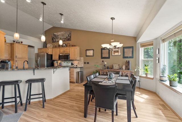 4812 S Wildwood Ln, Spokane, WA 99206 - dining space featuring a chandelier, light wood-type flooring, and high vaulted ceiling