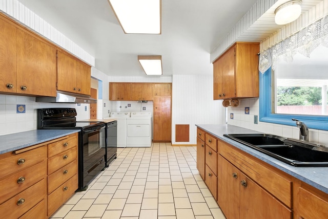 14807 E Broadway Ave, Spokane Valley, WA 99216 - kitchen with black electric range oven, washer and dryer, under cabinet range hood, and brown cabinets