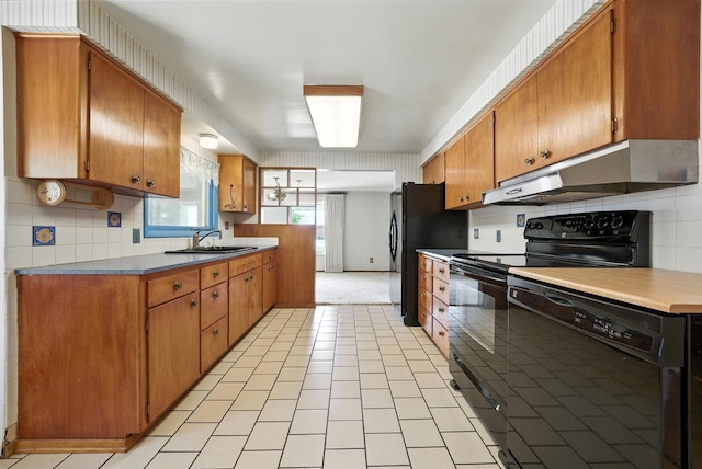 14807 E Broadway Ave, Spokane Valley, WA 99216 - kitchen featuring black appliances, under cabinet range hood, and brown cabinets