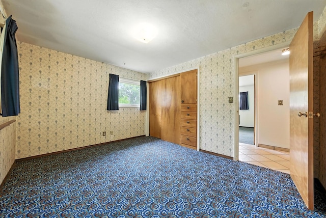 14807 E Broadway Ave, Spokane Valley, WA 99216 - unfurnished bedroom featuring wallpapered walls, a closet, and tile patterned flooring