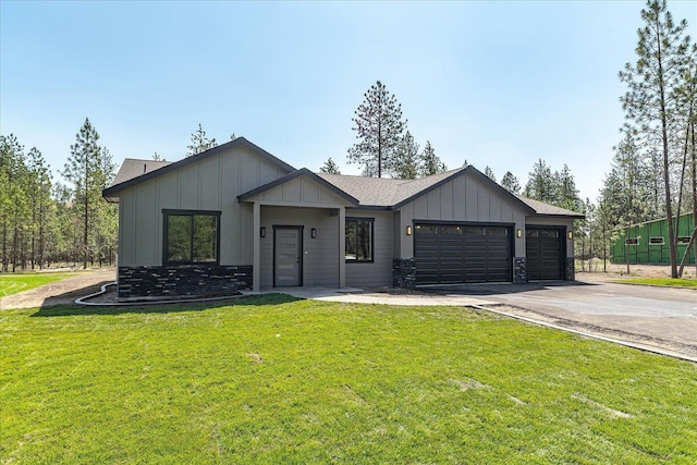 6571 Kate Dr, Nine Mile Falls, WA 99206 - modern farmhouse featuring driveway, a garage, board and batten siding, a front lawn, and roof with shingles