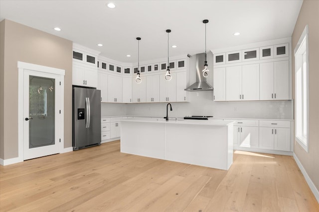 6571 Kate Dr, Nine Mile Falls, WA 99206 - kitchen featuring stainless steel refrigerator with ice dispenser, wall chimney range hood, light countertops, light wood-type flooring, and recessed lighting