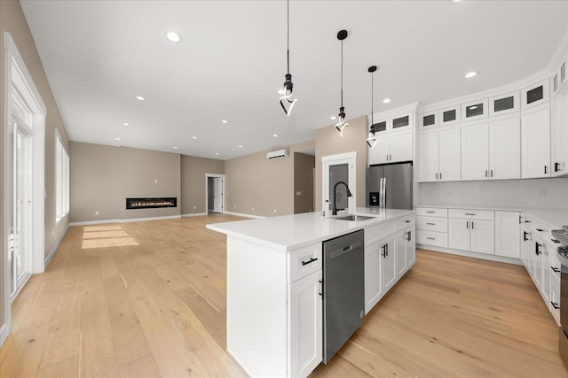 6571 Kate Dr, Nine Mile Falls, WA 99206 - kitchen with appliances with stainless steel finishes, an island with sink, light wood finished floors, pendant lighting, and white cabinets
