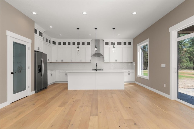 6571 Kate Dr, Nine Mile Falls, WA 99206 - kitchen featuring stainless steel refrigerator with ice dispenser, wall chimney exhaust hood, light countertops, light wood-type flooring, and recessed lighting