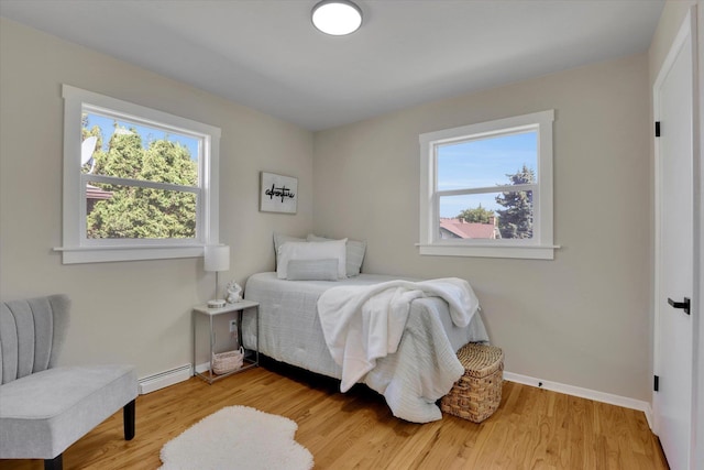 1406 S Cedar St Unit 1408, Spokane, WA 99203 - bedroom with multiple windows, a baseboard radiator, and wood finished floors