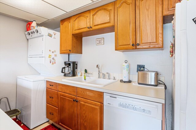 1716 N Pettet Dr Apt 2, Spokane, WA 99205 - kitchen with white appliances, stacked washer / dryer, light countertops, and brown cabinetry