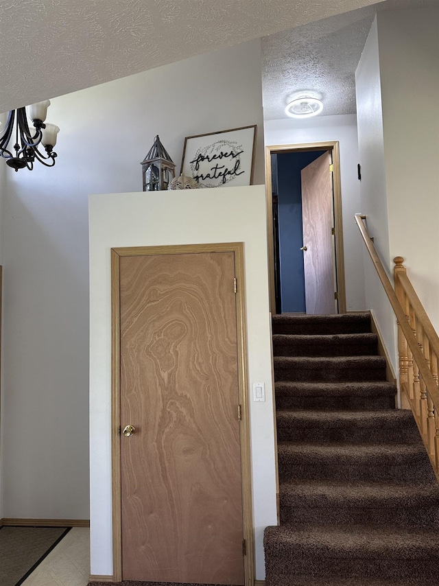 1612 E Sharpsburg Ave, Spokane, WA 99217 - stairway featuring a textured ceiling and a chandelier